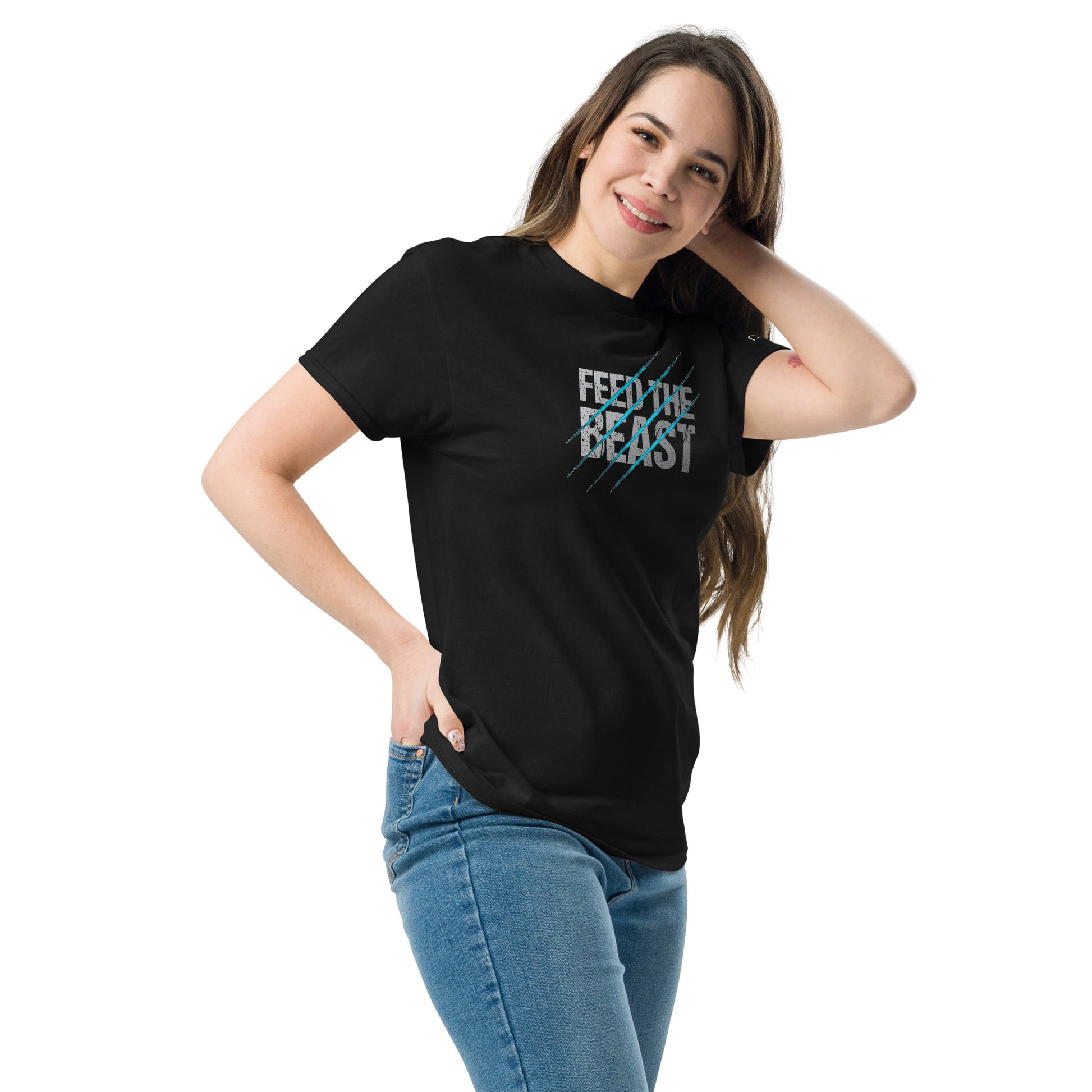 A young woman smiling, wearing a black t-shirt with a vibrant graphic that reads 'FEED THE BEAST' in large, distressed white and blue text with diagonal blue scratch marks, paired with blue jeans.