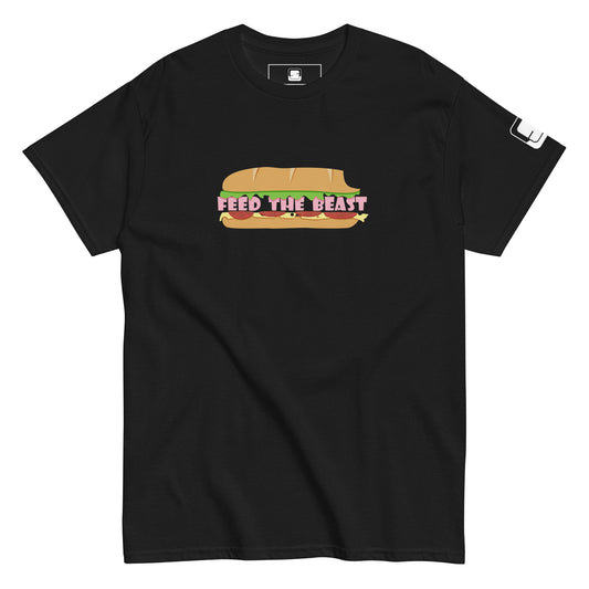 Black t-shirt showcasing a playful design with a sandwich graphic and the phrase 'FEED THE BEAST' depicted in colorful letters that mimic the sandwich's contents. The design incorporates shades of yellow, red, and green, providing a bright contrast against the dark shirt background.