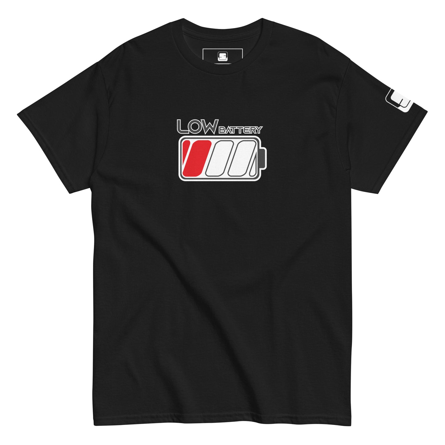 A black t-shirt displays the design "LOW BATTERY" in grey lettering with a white outline on the upper chest area. Below the text is a stylized battery icon with three sections; the leftmost cell is filled in red to indicate a low charge. The shirt has a casual fit with a ribbed crew neckline and short sleeves, each accented by a small black logo patch on the right sleeve.
