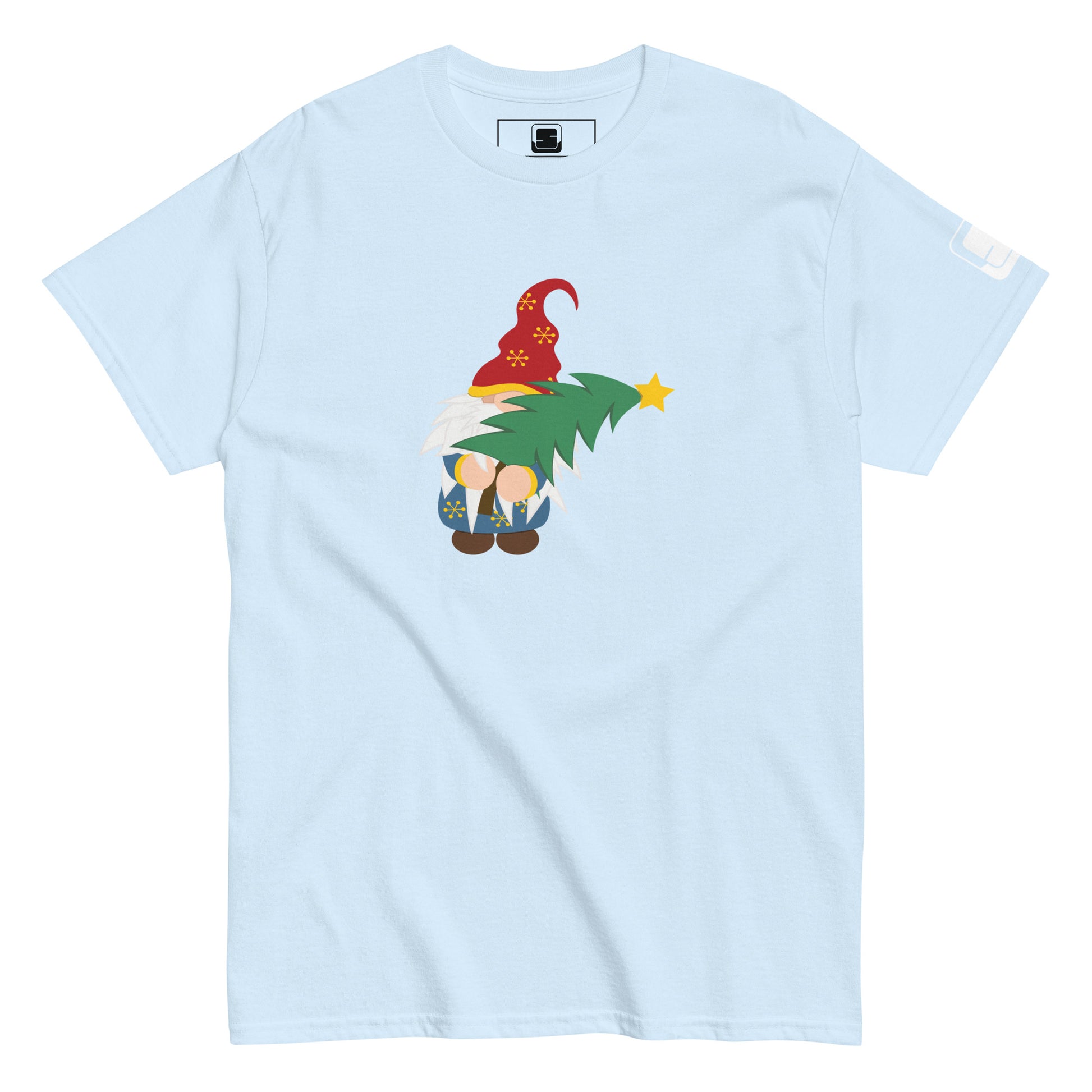 Light blue t-shirt featuring a colorful design of a gnome in a red hat decorated with yellow snowflakes, holding a green Christmas tree topped with a yellow star. The gnome is whimsically drawn with oversized white beard and tiny feet peeking out under a blue coat with golden snowflake details.