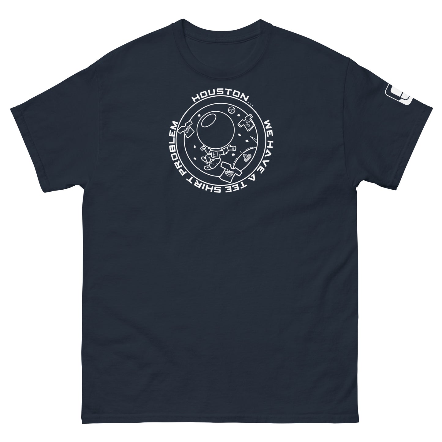 A simple yet bold navy t-shirt adorned with a white graphic playfully declaring "Houston...we have a tee shirt problem," encircling an astronaut and symbols of adventure in space including a planet, alian, and t-shirts, all arranged in a lighthearted, circular formation.