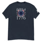 A dark navy t-shirt displayed flat, featuring a "July 4, 1776" graphic design in white, red, and blue. The design includes a central motif of blue with white stars arranged in a circle, framed by red and white stripes that emulate the American flag. The design symbolizes the United States' Independence Day. The date "1776" in white text enhances the historical significance, making it a patriotic choice for celebrating the Fourth of July.