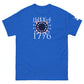 A royal blue t-shirt displayed flat, featuring a patriotic design. The design includes "July 4, 1776" in white, set against a flag motif with red and white stripes and a blue field of white stars arranged in a circular pattern to evoke a firework. The striking design symbolizes American heritage and is perfect for Fourth of July celebrations.