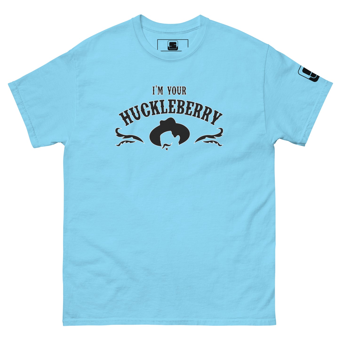 A light blue t-shirt features the bold phrase "I'm Your Huckleberry" in dark lettering arched over a Western-style silhouette of a cowboy hat. The design is accented with elegant black filigree details on either side, encapsulating a classic Western aesthetic on the shirt's front.