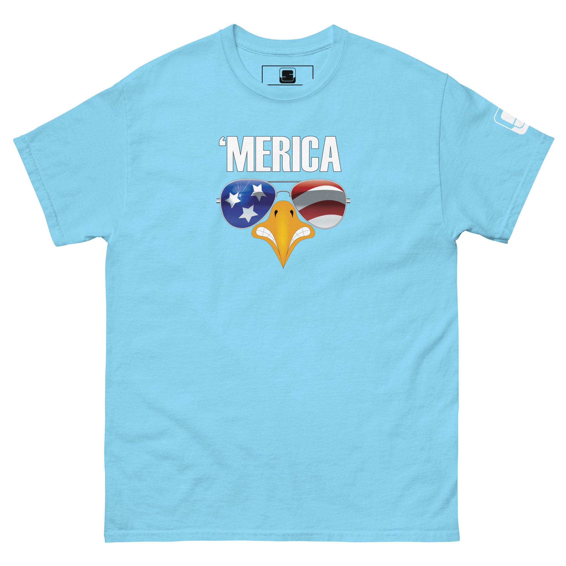 A light blue t-shirt displayed flat, adorned with a humorous and patriotic graphic. The shirt features the phrase "'MERICA" in large, uppercase letters, with a stylized eagle's beak depicted below it. The beak is designed with aviator sunglasses that reflect American symbolism: the left lens has a blue background with white stars, and the right lens showcases red and white stripes, mimicking the American flag. This spirited design emphasizes American pride in a lighthearted manner.