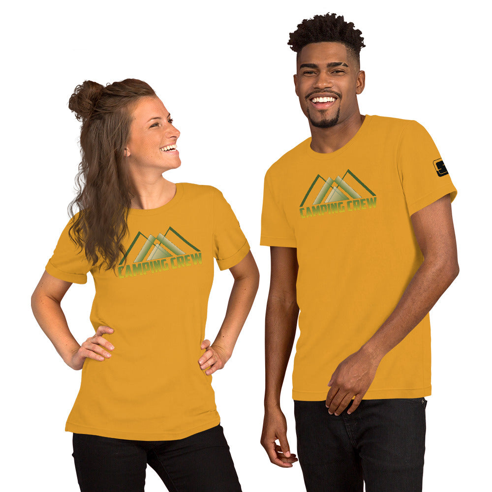 A cheerful Caucasian woman and an African American man, both wearing golden yellow t-shirts, share a light-hearted moment. The t-shirts display an abstract mountain motif above green to yellow gradient text that says 'Camping Crew'. They are positioned against a neutral background, looking to the side with broad smiles, highlighting the casual and friendly vibe of the t-shirt design ideal for group outdoor activities."