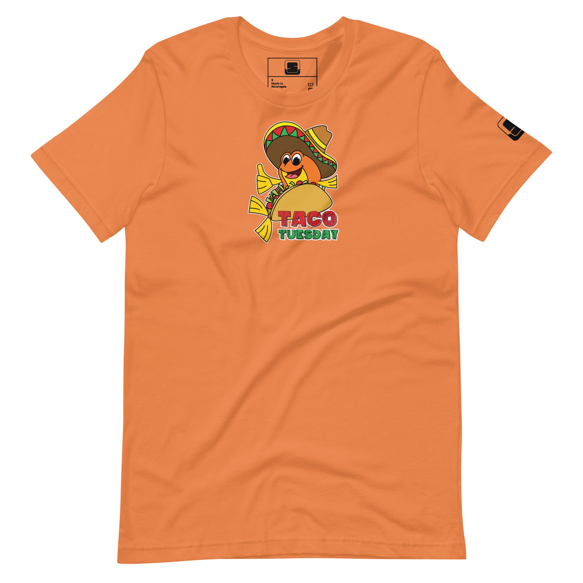 An orange-colored t-shirt laid flat, adorned with a "Taco Tuesday" graphic. The design showcases a playful fish in a taco, complete with a colorful sombrero, happily giving a thumbs up. The graphic's background is a vibrant yellow, with the words "Taco Tuesday" in bold, colorful letters, evoking a festive and lively spirit. The overall look is casual and fun, perfect for a themed event or casual wear.