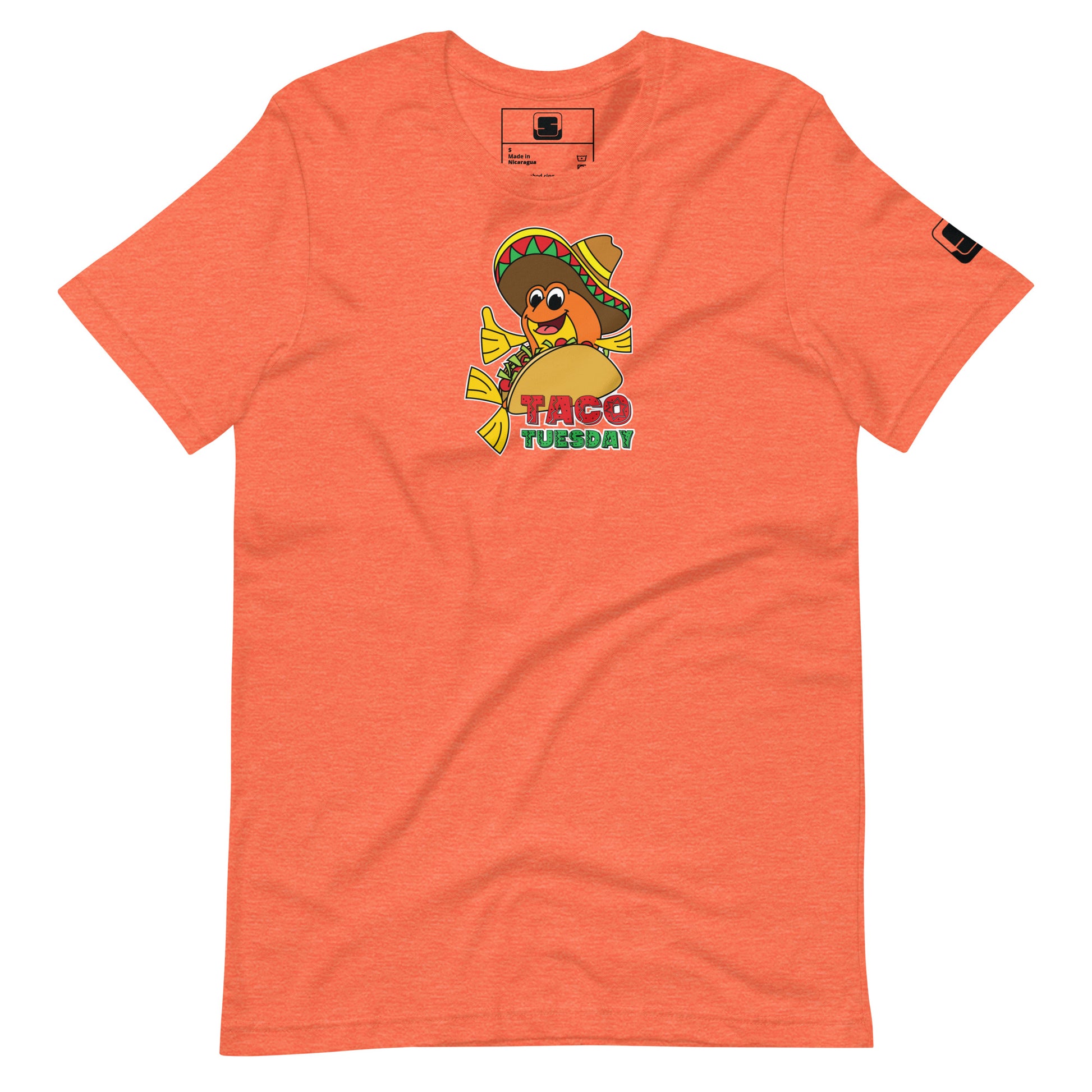 An orange t-shirt displayed flat, featuring a vibrant "Taco Tuesday" graphic. The graphic shows a cheerful fish, tucked inside a taco and wearing a multicolored sombrero, giving a thumbs up. The illustration is playful, with the text "Taco Tuesday" in a fun, colorful font below the image, set against the taco shell. The design is whimsical and festive, ideal for casual outings or themed events.