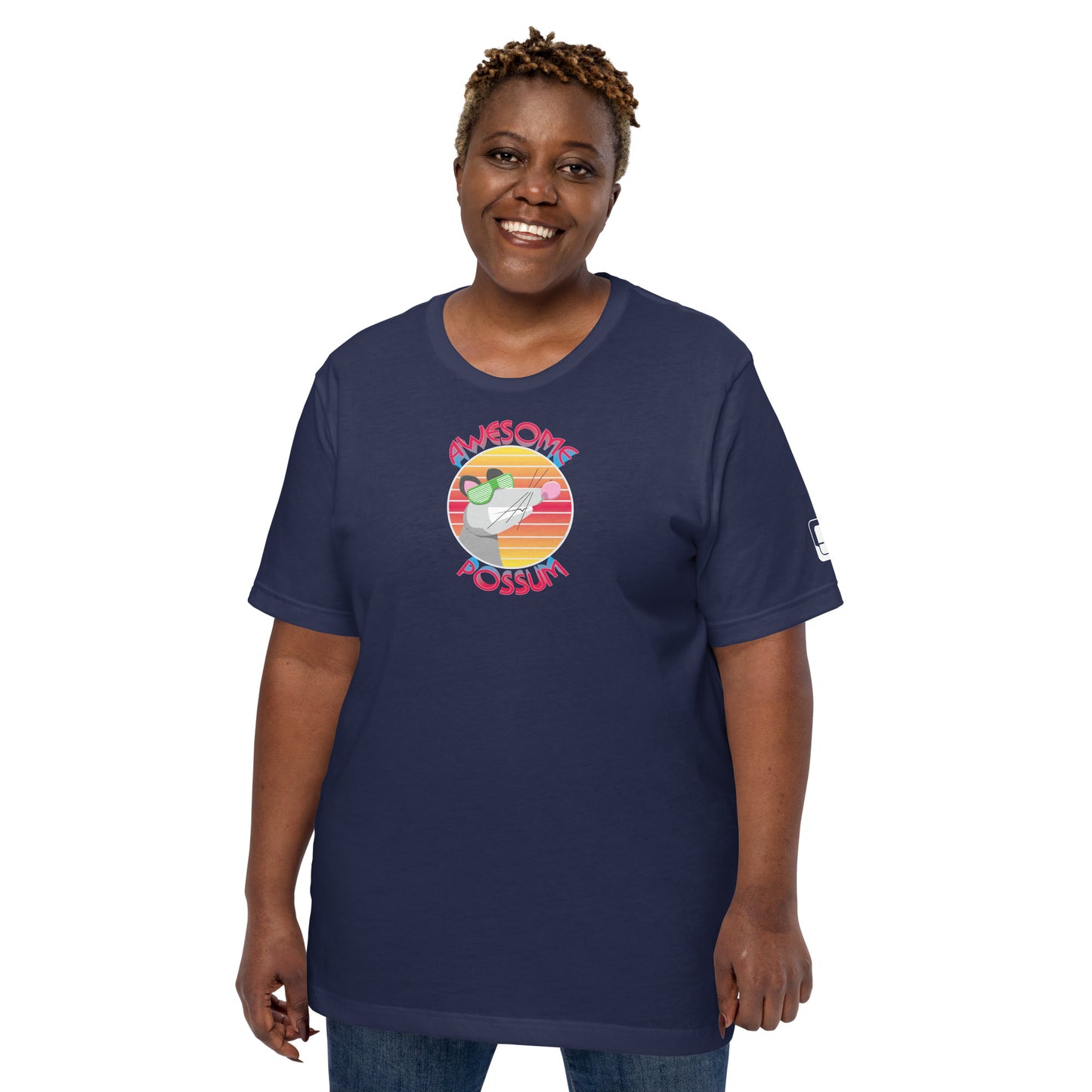 
A cheerful African American woman with short, tightly curled hair smiles warmly at the camera, wearing a navy blue t-shirt that showcases the whimsical "AWESOME POSSUM" design. The t-shirt features a cartoon possum wearing green sunglasses within a colorful circle, underlined by the playful words in a bold, rounded font. Her joyful expression enhances the fun and laid-back vibe of the outfit.