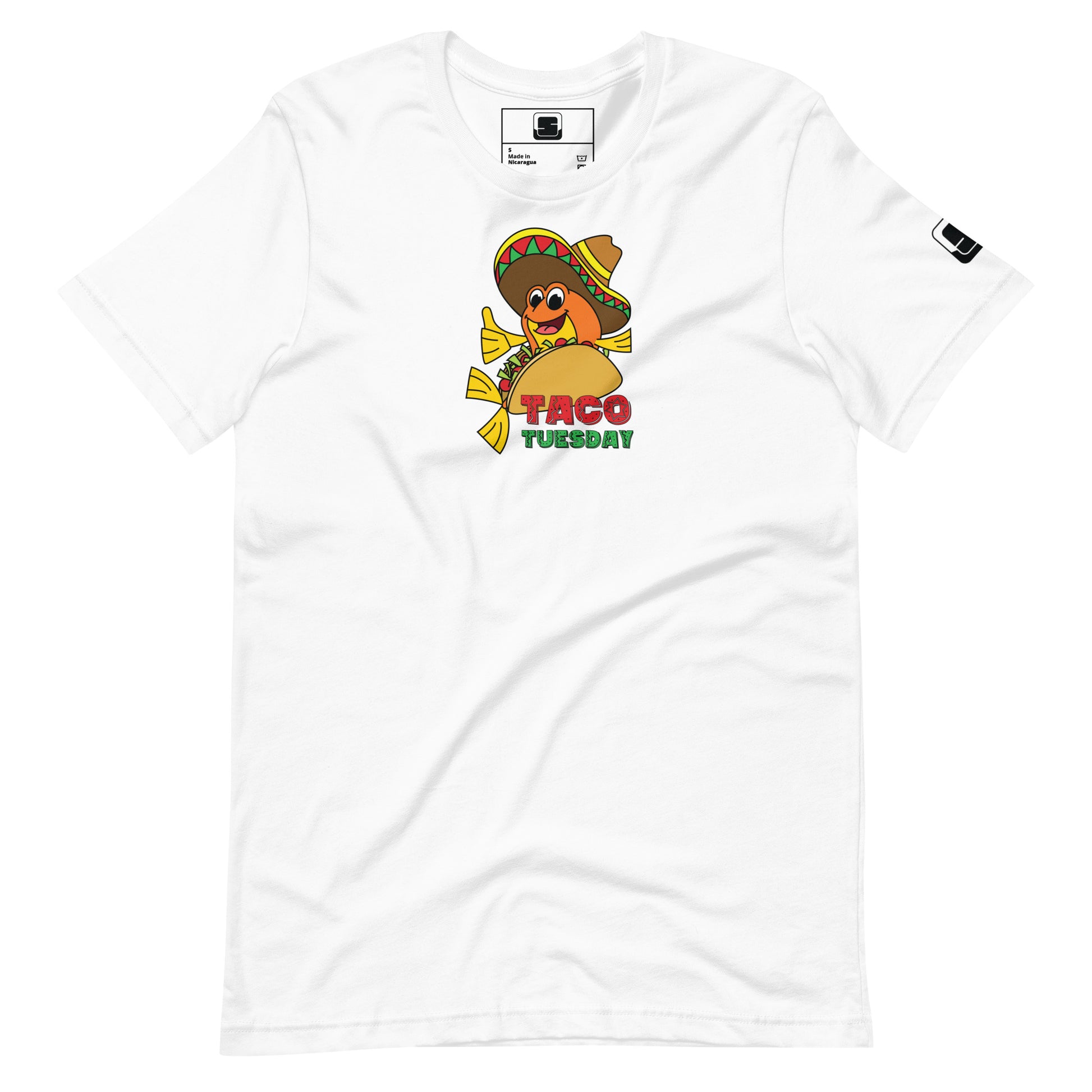 A plain white t-shirt laid flat, featuring a colorful "Taco Tuesday" graphic. The design includes a cheerful fish wearing a sombrero, nestled within a taco, giving a thumbs up. The background of the graphic is bright yellow, complementing the vibrant red and green text that spells out "Taco Tuesday," capturing a fun and festive vibe.