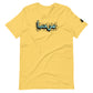 Lemon yellow t-shirt featuring central turquoise Arabic calligraphy with black shadow and scattered ink dots, accompanied by a small black logo patch on the sleeve, displayed against a white background.